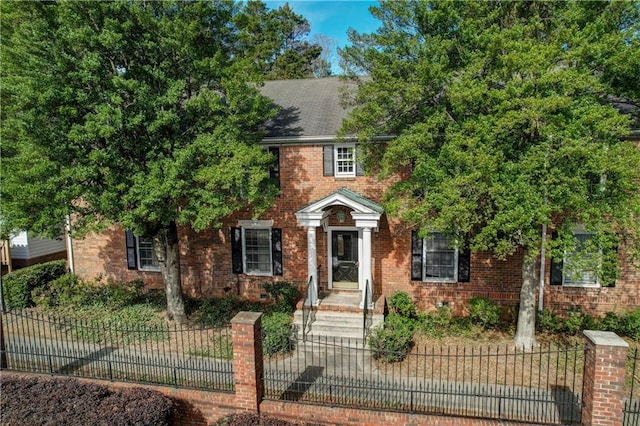 view of front of house featuring brick siding and a fenced front yard