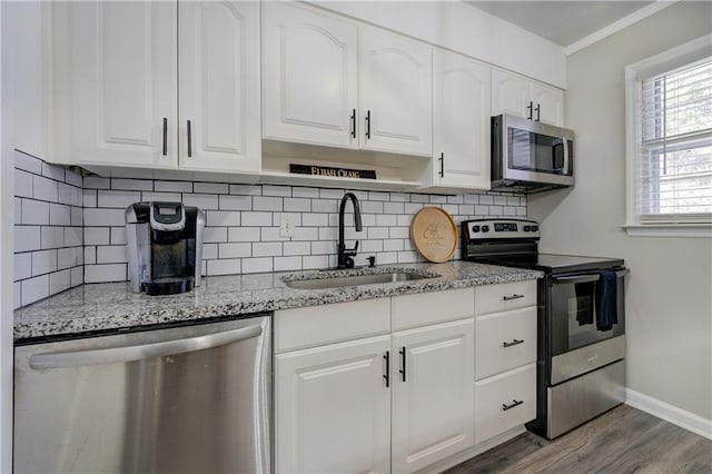 6700 Roswell Rd Unit 32C, Atlanta, GA 30328 - kitchen featuring stainless steel appliances, a sink, baseboards, white cabinets, and crown molding