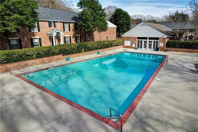 6700 Roswell Rd Unit 32C, Atlanta, GA 30328 - community pool with french doors, a patio, an outbuilding, and a storage structure