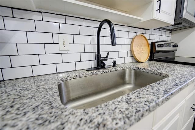 6700 Roswell Rd Unit 32C, Atlanta, GA 30328 - kitchen view of a sink, backsplash, stainless steel range with electric cooktop, and light stone counters