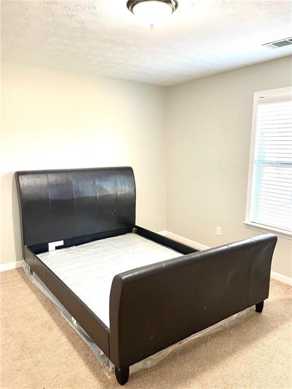 carpeted bedroom with a textured ceiling