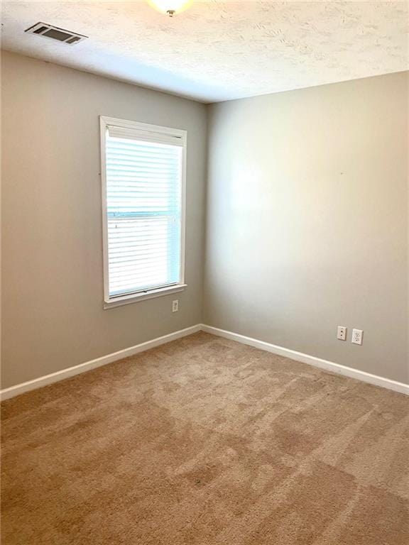 unfurnished room featuring carpet flooring and a textured ceiling