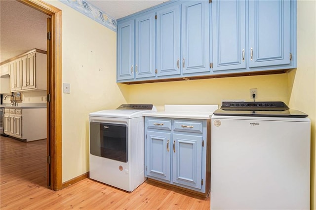 1488 White Columns Blvd, Canton, GA 30115 - washroom with light wood-style flooring, cabinet space, and washer and clothes dryer