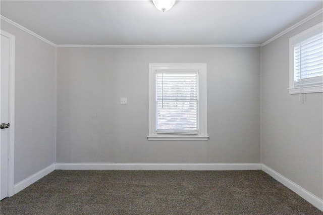 empty room featuring dark colored carpet and ornamental molding