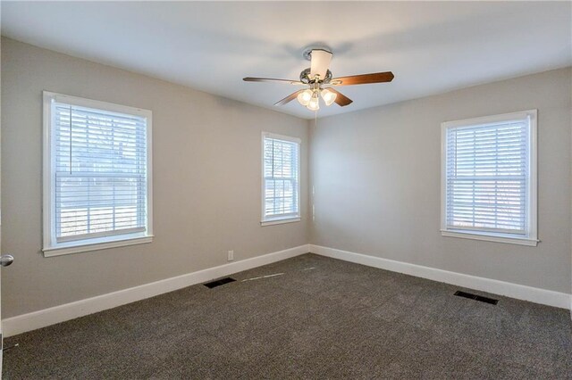 unfurnished room featuring dark carpet and ceiling fan