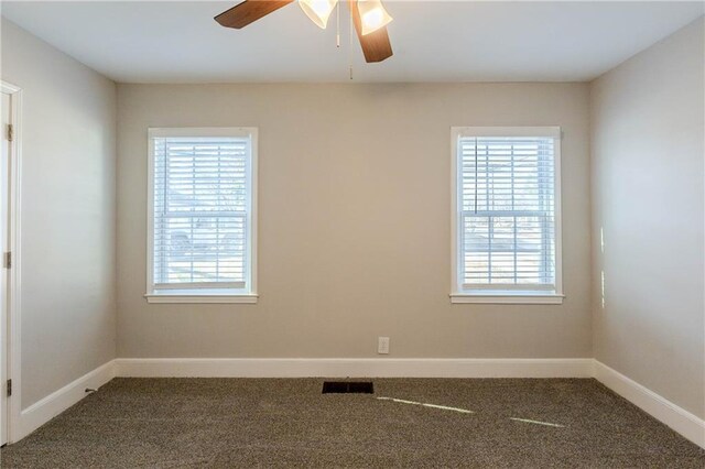 carpeted empty room featuring ceiling fan and a wealth of natural light