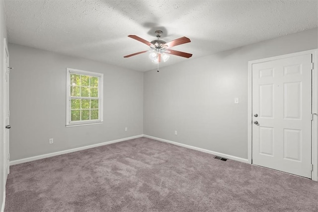 unfurnished room with a textured ceiling, carpet, and ceiling fan