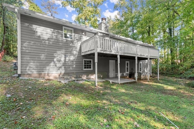 rear view of house featuring a yard, a patio, and a deck