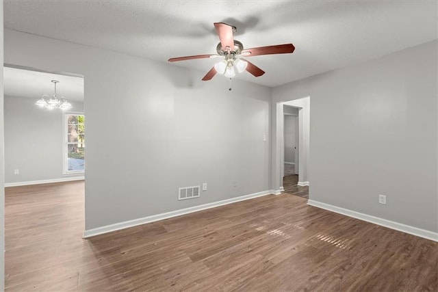 unfurnished room featuring dark hardwood / wood-style floors and ceiling fan with notable chandelier