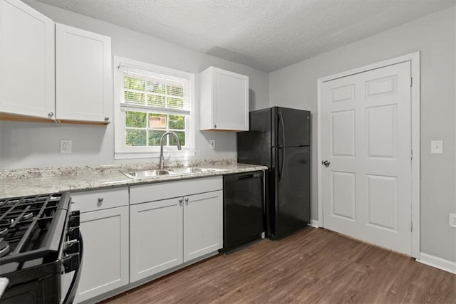 kitchen with white cabinets, a textured ceiling, dark hardwood / wood-style floors, black appliances, and sink