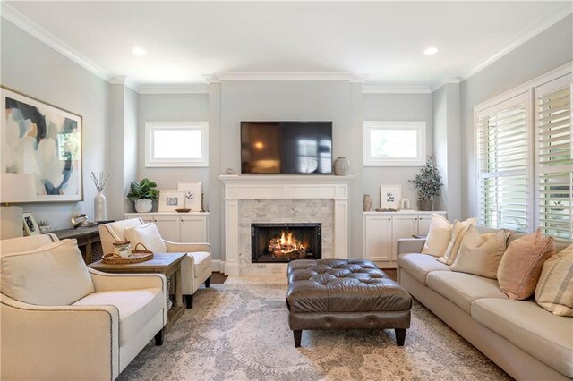 living area featuring a high end fireplace, crown molding, recessed lighting, and a healthy amount of sunlight