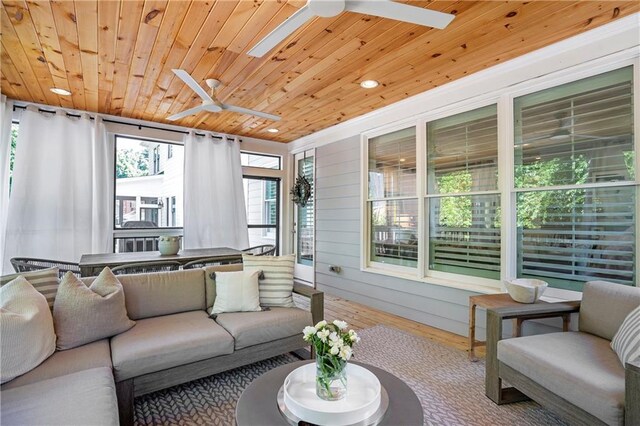 living area with plenty of natural light, a ceiling fan, and hardwood / wood-style flooring
