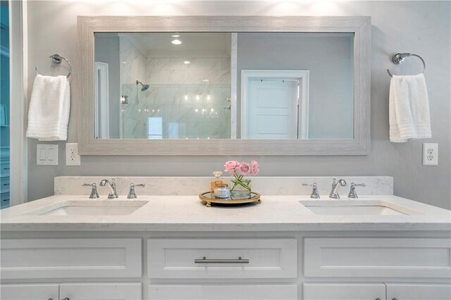 full bath with a sink, a shower stall, and double vanity