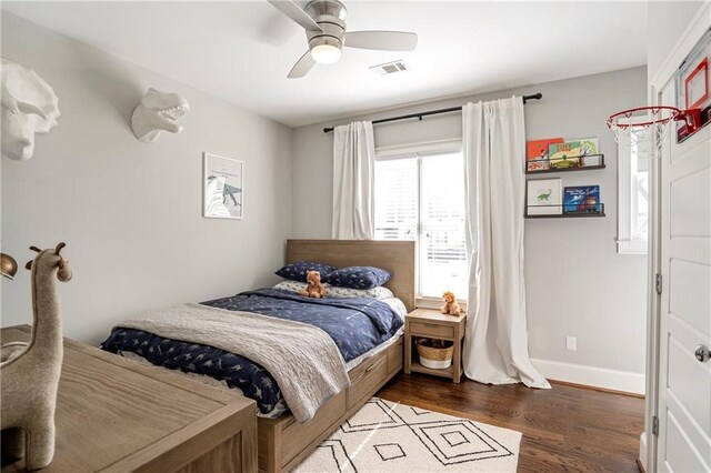 bedroom with visible vents, a ceiling fan, baseboards, and wood finished floors