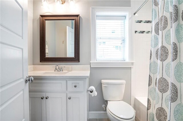 bathroom with vanity, baseboards, toilet, and shower / tub combo with curtain