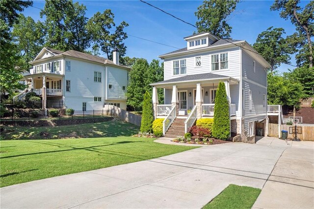 traditional style home with fence, stairs, a front lawn, concrete driveway, and covered porch