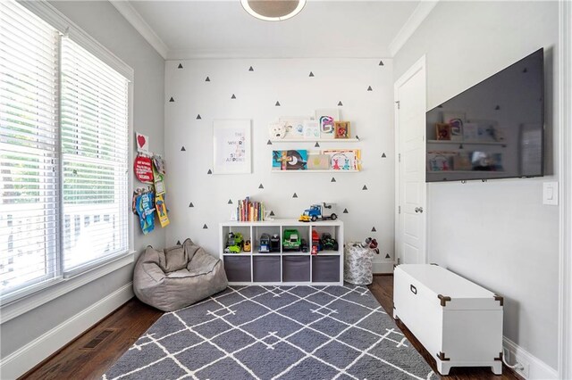 game room featuring visible vents, ornamental molding, and dark wood-style flooring