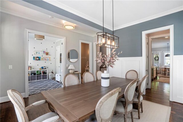 dining room with crown molding, wainscoting, and dark wood-type flooring