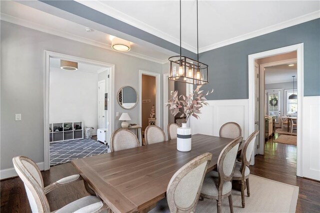 dining area featuring ornamental molding, wainscoting, and dark wood-style floors