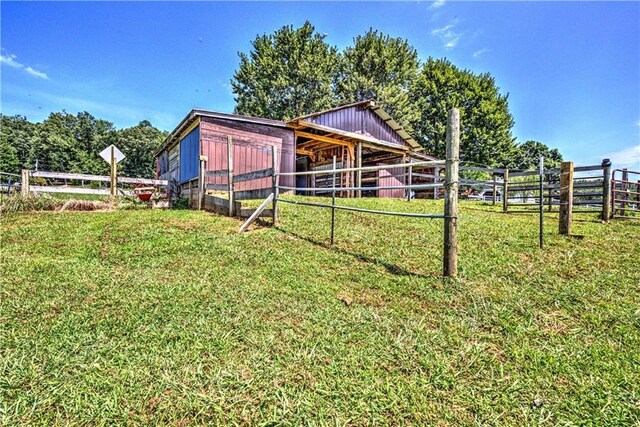 view of yard with a rural view and an outdoor structure