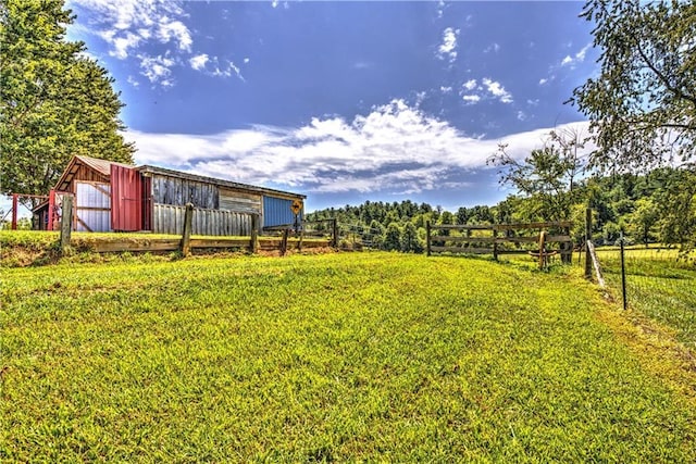 view of yard with an outbuilding, a pole building, and fence