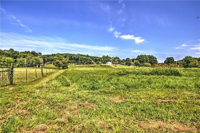 view of yard featuring a rural view and fence