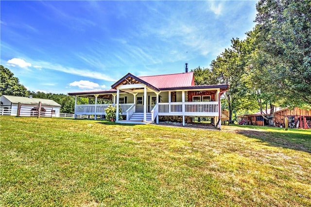 view of front of property featuring a front lawn, an outbuilding, and covered porch