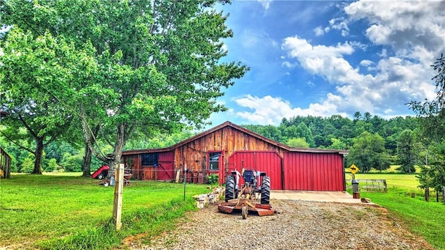 view of front of home featuring a front yard, a barn, and an outdoor structure