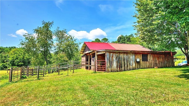 view of side of property featuring metal roof, an outdoor structure, and an exterior structure