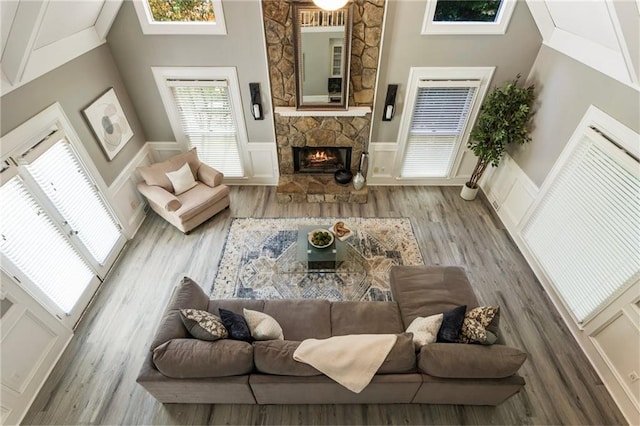 910 Kings Arms Way, Johns Creek, GA 30022 - living room featuring a decorative wall, a stone fireplace, wood finished floors, and wainscoting