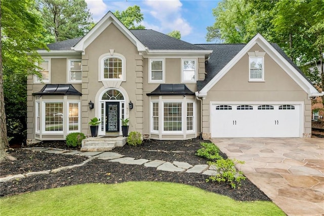 910 Kings Arms Way, Johns Creek, GA 30022 - view of front of home featuring stucco siding, driveway, a garage, and roof with shingles