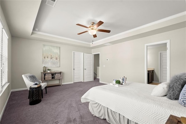 bedroom with a tray ceiling, dark carpet, visible vents, and baseboards