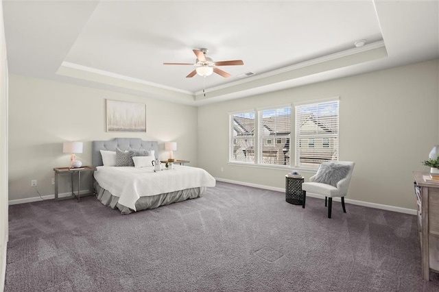 bedroom featuring ceiling fan, dark carpet, a raised ceiling, and baseboards