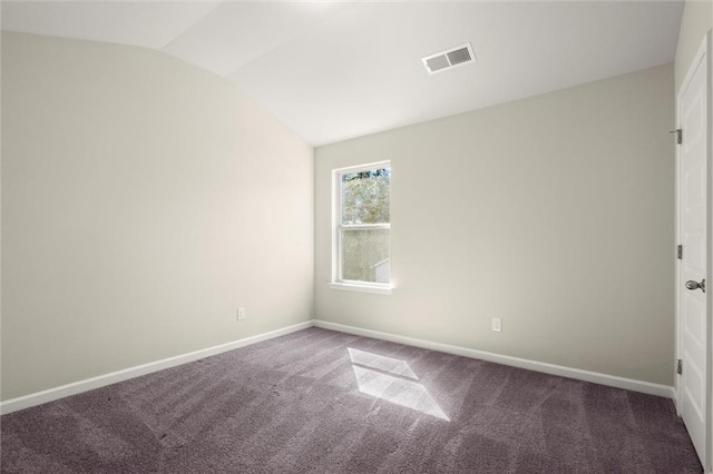 spare room with carpet floors, baseboards, visible vents, and vaulted ceiling