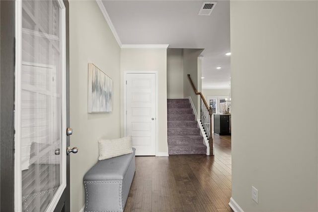 foyer with visible vents, baseboards, stairs, dark wood finished floors, and crown molding