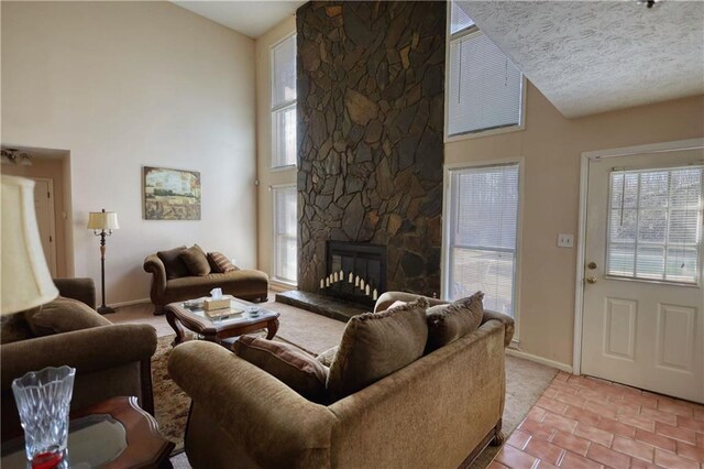 744 Hampton Locust Grove Rd, Hampton, GA 30228 - living room featuring a wealth of natural light, a textured ceiling, a stone fireplace, and a high ceiling