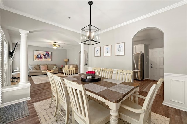 dining room with arched walkways, dark wood-style floors, ornate columns, and ceiling fan