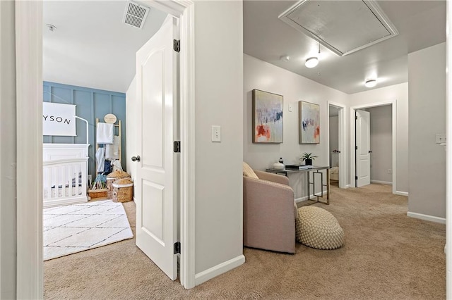 corridor with carpet flooring, attic access, baseboards, and visible vents