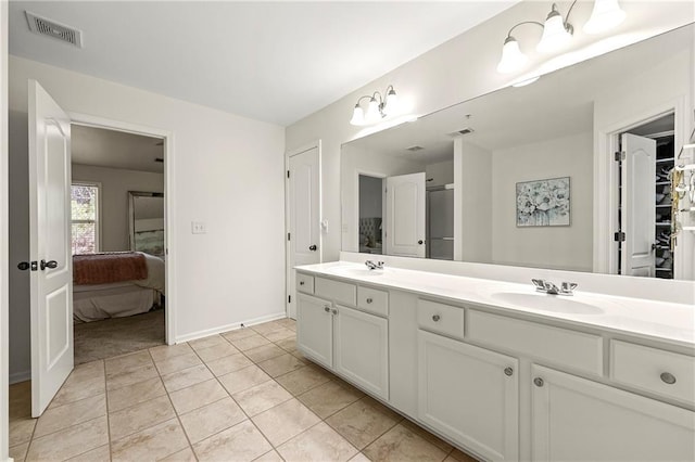 ensuite bathroom featuring visible vents, a sink, connected bathroom, tile patterned flooring, and double vanity