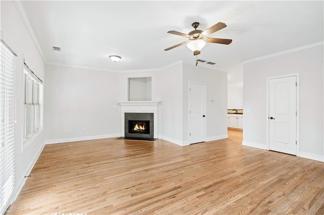 unfurnished living room featuring ceiling fan, crown molding, and light wood-type flooring