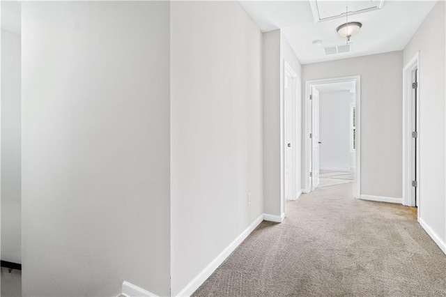 hallway featuring light colored carpet