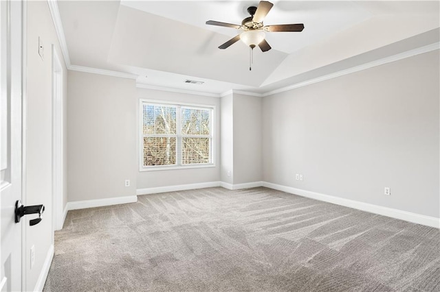 unfurnished room featuring a raised ceiling, light colored carpet, ceiling fan, and ornamental molding