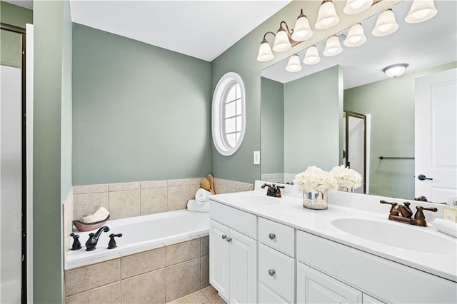 bathroom featuring tiled bath, vanity, and tile patterned flooring