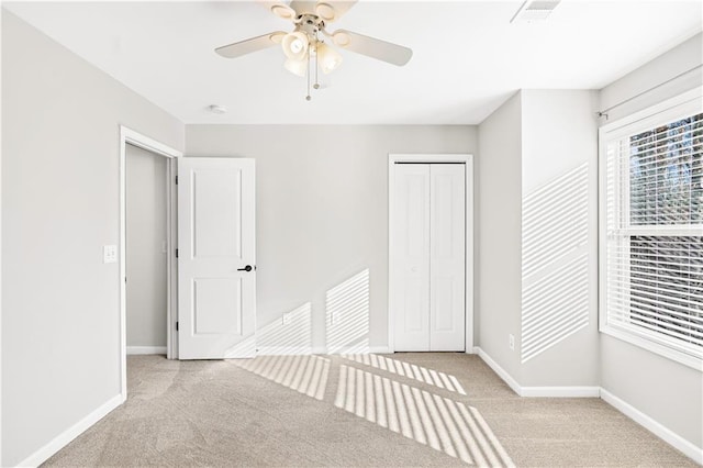 unfurnished bedroom with ceiling fan, a closet, and light colored carpet