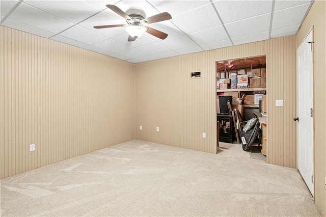 carpeted spare room featuring ceiling fan and a paneled ceiling