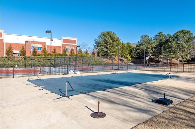 view of swimming pool with basketball hoop