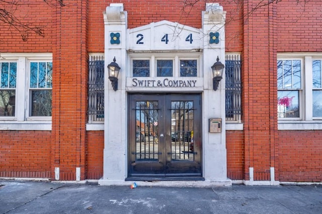 entrance to property featuring french doors and brick siding