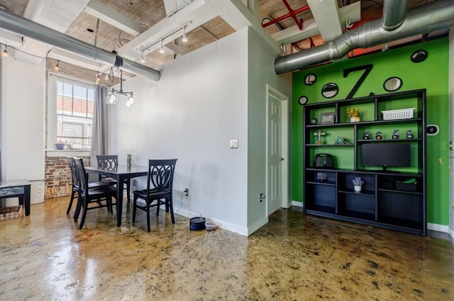 dining area featuring finished concrete flooring, an inviting chandelier, rail lighting, and baseboards