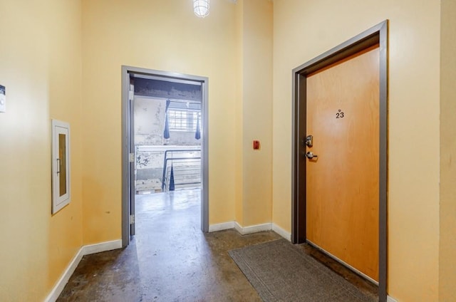 interior space featuring baseboards and unfinished concrete floors