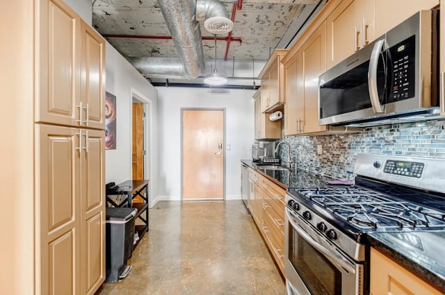 kitchen featuring stainless steel appliances, decorative backsplash, a sink, concrete flooring, and baseboards